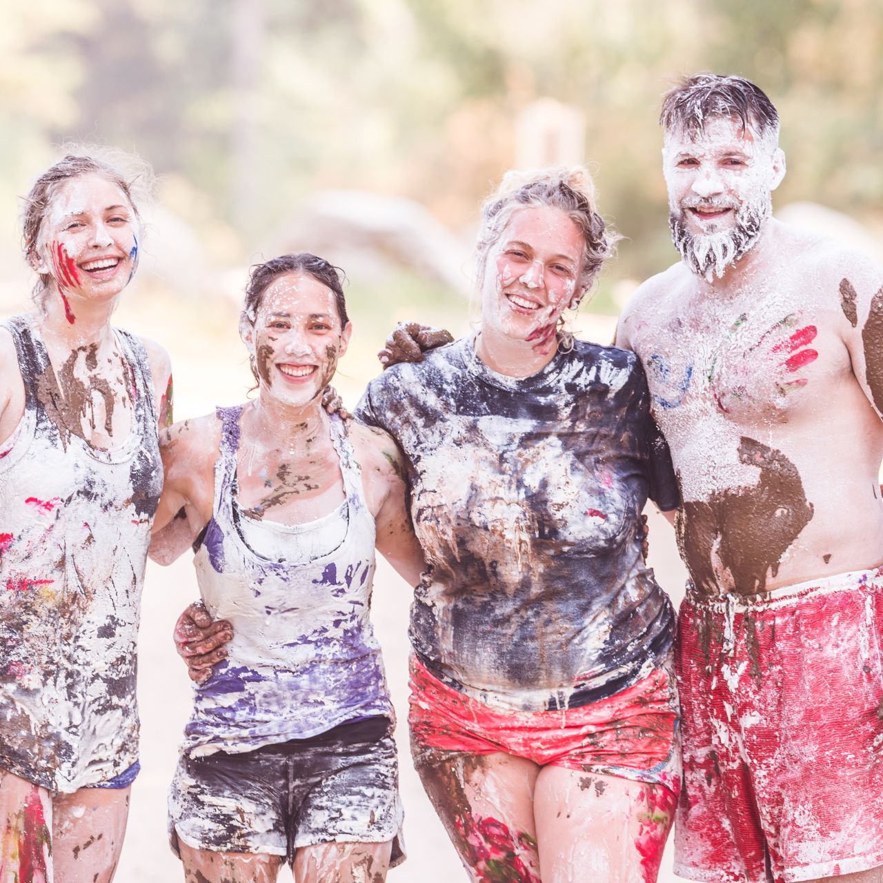 Smiling supporters covered in mud at a charity fun run